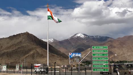 Bandera-Ondeando-Y-Moviéndose-A-Cámara-Lenta-En-La-Ciudad-De-Leh-Ladakh-Con-Vehículos-En-Movimiento