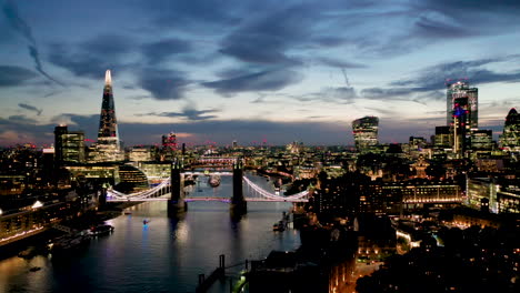 Aerial-View-of-London-over-the-River-Thames-including-Tower-Bridge,-Shard-and-the-Tower-of-London-at-twilight
