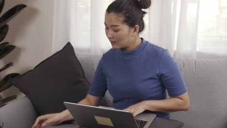 Authentische-Aufnahme-Einer-Asiatischen-Geschäftsfrau,-Die-Einen-Laptop-Benutzt,-Um-Glücklich-Von-Zu-Hause-Aus-Zu-Arbeiten