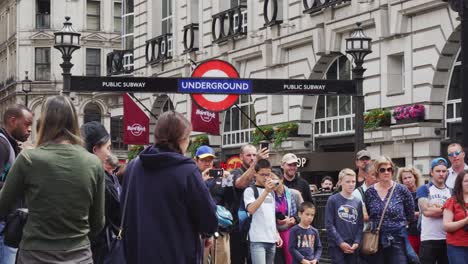Menschenmenge,-Die-Straßenaufführungen-Zuhört-Und-Beobachtet---Straßenmusik-Unter-Dem-U-Bahn-Schild-In-London