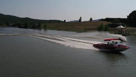 Aerial-view-tracking-speed-boat---water-skier-slalom-course-run