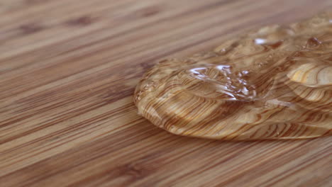 Hand-Sanitizer-Gel-Fluid-Spilled-And-Gliding-On-Wooden-Surface