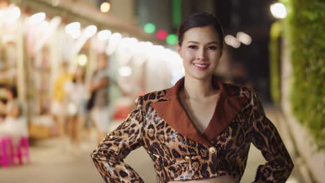Schönes-Asiatisches-Mädchen-Mit-Atemberaubendem-Und-Verführerischem-Lächeln-Blickt-In-Die-Kamera-Und-Posiert-Nachts-In-Der-Stadt