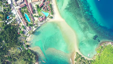 Thailand,-Aerial---Aquamarine-sea-water-and-sandy-beach-in-front-of-the-luxury-resort-with-swimming-pools