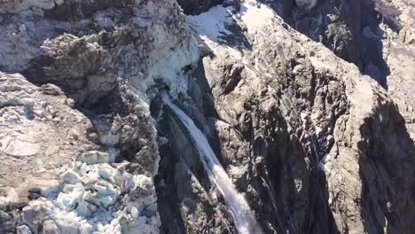 Aerial-approach-to-a-waterfall-of-glacier-melt-water-in-summer-at-the-Swiss-alps