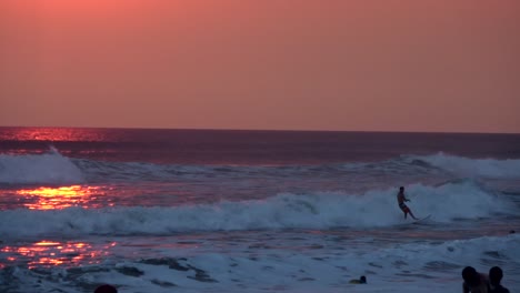 Ein-Surfer-Reitet-Auf-Einer-Welle-Mit-Einem-Wunderschönen-Sonnenuntergang-Im-Hintergrund-In-Der-Nähe-Von-Santa-Teresa,-Costa-Rica