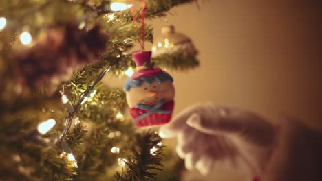 Santa-Claus-reaching-to-look-at-a-snowman-ornament