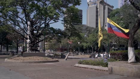 Venezuelan-flag-waving-in-Francia-Square,-also-known-as-Altamira-Square,-in-Chacao,-Caracas,-Venezuela