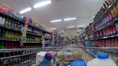 Inside-supermarket-shopping-cart-pushing-trolley-down-cleaning-aisle-as-customers-shop-during-corona-virus-pandemic