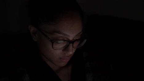 Junge-Asiatische-Frau-Aus-Großbritannien,-Die-Eine-Brille-Trägt-Und-Nachts-Videos-Auf-Dem-Handy-Anschaut