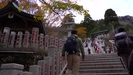 Walking-up-stone-steps-towards-famous-Afuri-Jinja-near-Tokyo,-Japan-during-fall