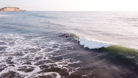 Surfers-Paddling-In-Ocean-With-Breaking-Waves-Near-Olon-Beach-In-Summer