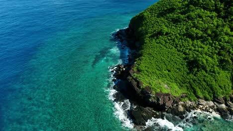 Tropical-nature-of-a-Fijian-Island-surrounded-by-perfect-blue-water,-aerial-shot