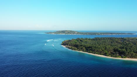 Mar-Azul-Que-Rodea-Islas-Tropicales-Con-Vegetación-Exuberante-Y-Playa-De-Arena-Blanca-En-Un-Cielo-Abierto-Brillante-Y-Claro-En-Bali,-Espacio-Para-Copiar