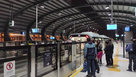 El-Tren-Ligero-De-Tránsito-Rápido-De-Macao-Llega-A-La-Estación-Mientras-Los-Pasajeros-Esperan-Para-Abordar