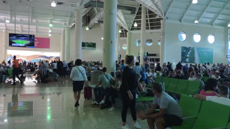 Terminal-Del-Aeropuerto-De-Punta-Cana,-Los-Pasajeros-Esperan-Para-Abordar-Sus-Vuelos