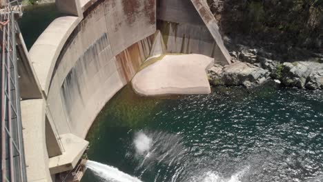 man-leaps-off-Yuba-River-dam,-double-extended-back-flip-into-pool