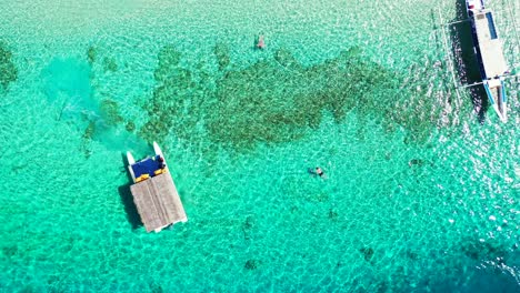 Tourenboote-Schweben-über-Dem-Ruhigen,-Klaren-Wasser-Der-Türkisfarbenen-Lagune,-Wo-Menschen-über-Wunderschönen-Korallenriffen-Schnorcheln-Und-Tropische-Fische-In-Malaysia-Beobachten