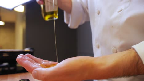 Der-Koch-Gießt-Olivenöl-Auf-Seine-Hände