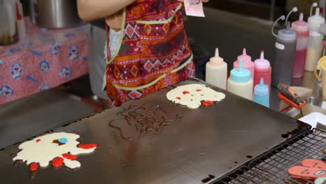 Woman-preparing-Cartoon-shaped-pancakes-on-flat-grill,-Bangkok