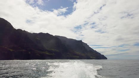 4K-Hawaii-Kauai-Boating-on-ocean-view-from-the-back-of-the-boat-with-wake-and-mountains-along-shoreline-in-distance