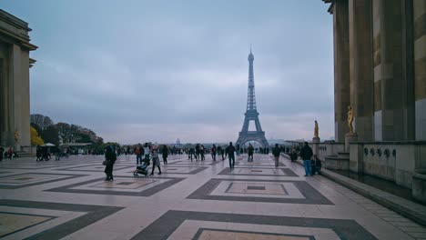 Tourists-on-an-overcast-day-walk-across-the-Palais-de-Chaillot-with-the-Eiffel-Tower-in-the-background,-Paris,-France