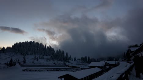 A-Mountain-Village-Covered-In-Winter-Snow-With-Cloudy-Sky-At-Sunset---Time-Lapse