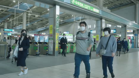 Tokio,-Japan-–-Menschen-Mit-Gesichtsmasken,-Die-Durch-Die-Fahrkartenschalter-Am-Bahnhof-Shinagawa-Jr.-Gehen-–-Zeitlupe