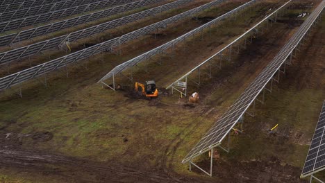 excavator-digs-underneath-solar-power-panels-in-the-solar-power-plant