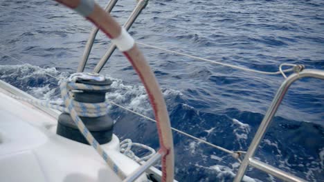 Helm-And-Winch-Of-A-Sailboat-Sailing-Across-The-Blue-Sea---extreme-close-up