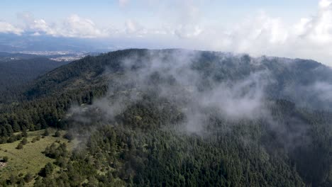 Aerial-view-of-dense-forest-near-Mexico-city-and-beautiful-Clouds