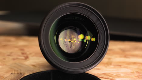 Camera-Lens-Showing-Small-Aperture-With-Yellow-Bokeh-Light-On-Mirror