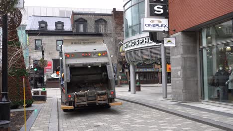A-garbage-truck-with-flashing-lights-is-moving-on-the-street