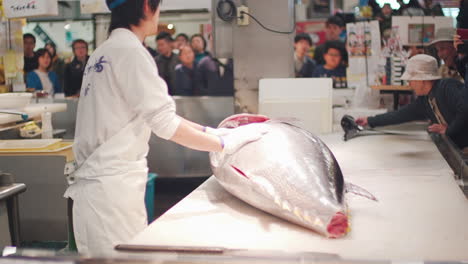 A-Butcher-To-Cut-The-Head-Of-A-Big-Bluefin-Tuna-In-Front-Of-Japanese-People-At-The-Toretore-Ichiba-Fish-Market-In-Wakayama,-Japan---medium-shot