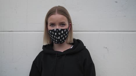 Portrait-of-young-woman-with-protective-face-mask-looking-at-camera-slow-motion