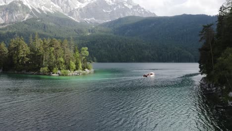 Following-a-boat-on-lake-Eibsee-from-above-during-a-sunny-day