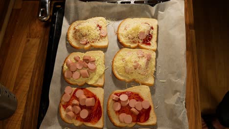 Adding-grated-cheese-on-top-of-homemade-student-style-sandwiches-for-cooking-in-hot-oven