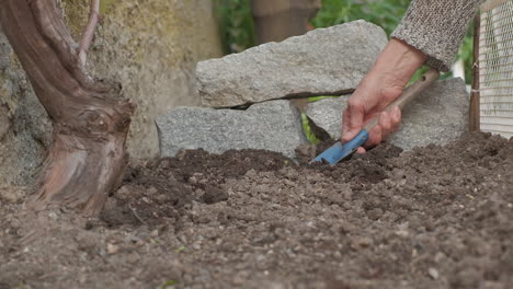 Farmer-hoeing-the-soil,-gardener-with-shovel-preparing-the-ground-for-home-garden-organic-cultivation