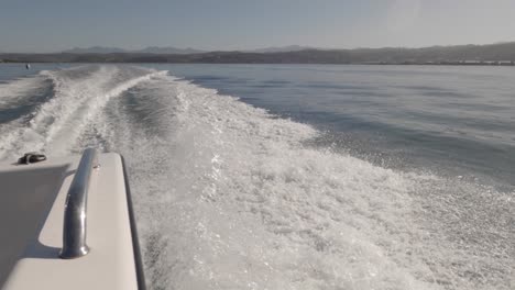 POV-rear-and-side-wake-from-powerboat-motoring-offshore-on-sunny-day
