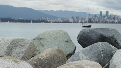 Rocks-with-cityscape-and-a-sailboat-in-the-background