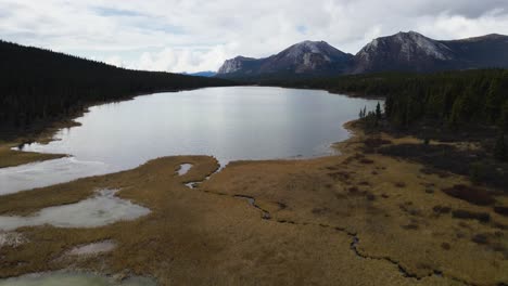 Johnson-Range-lake's-mountainous-landscape,-fly-out-drone-shot