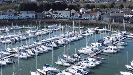 Sailboats-and-yachts-moored-along-Conwy-marina-luxury-waterfront-aerial-view-left-dolly-slow-shot