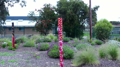 Aboriginal-Paintings-On-Wooden-Poles-In-A-School-Garden