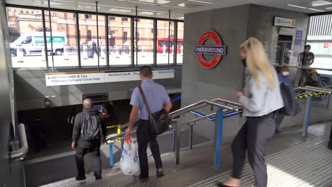 Menschen-Mit-Gesichtsmasken-Gehen-Die-Treppe-Hinunter-Und-Betreten-Den-Bahnhof-Kings-Cross,-St.-Pancras,-London,-Großbritannien