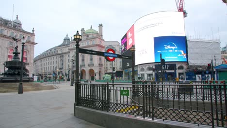 Lockdown-in-London,-Piccadilly-Circus-underground-completely-empty,-with-flying-birds-and-one-lone-cyclist,-during-the-corona-virus-pandemic-2020
