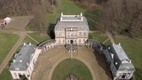 Aerial-reveal-of-classic-baroque-moated-castle-Huis-de-Voorst-in-Eefde-on-a-sunny-day-with-surrounding-park