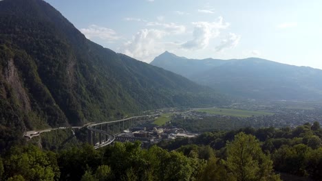 Aerial-approach-to-an-industrial-area-and-huge-bridge-in-the-mountains