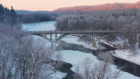 Passage-über-Einen-Zugefrorenen-Fluss,-Der-An-Einem-Wintermorgen-Von-Einer-Brücke-überquert-Wird