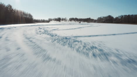 Low-and-fast-flying-drone-footage-of-Porsche-carrera-2020-911-4S-drifting-on-frozen-Lake-in-circle-shaped-track
