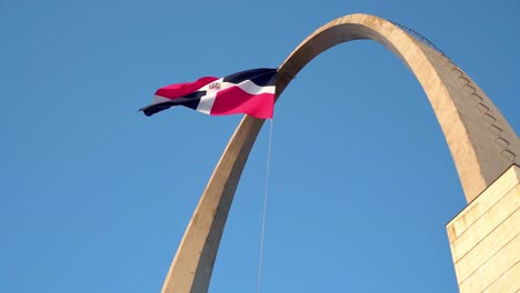Zeitlupe-Der-Flagge-Der-Dominikanischen-Republik,-Die-über-Dem-Triumphbogen-Auf-Dem-Flaggenplatz-Weht